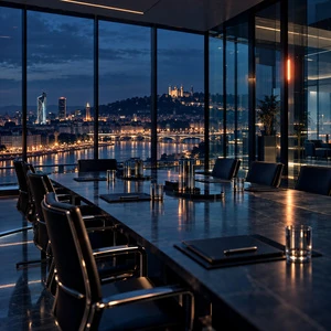 Une salle de conseil vitrée et vide devant les lumières de la ville.